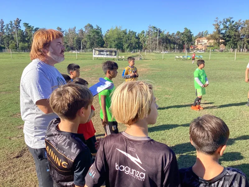 Facundo Alfaro junto a futbolistas infantiles en una cancha